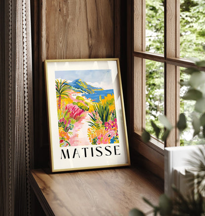 Framed art print showing coastal path with flowers, palm tree, and sea view