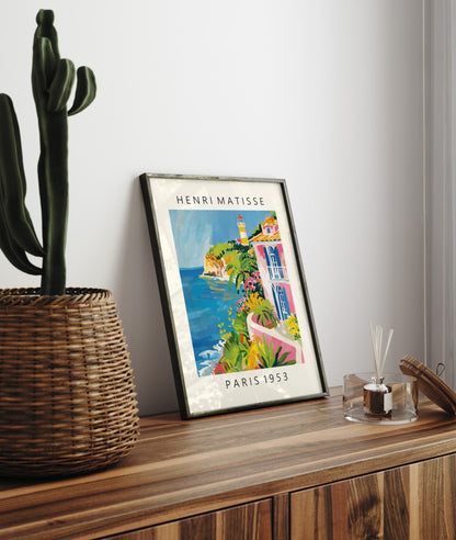 Framed seaside art print of colorful villa with flowers, palm trees, and ocean in Matisse style