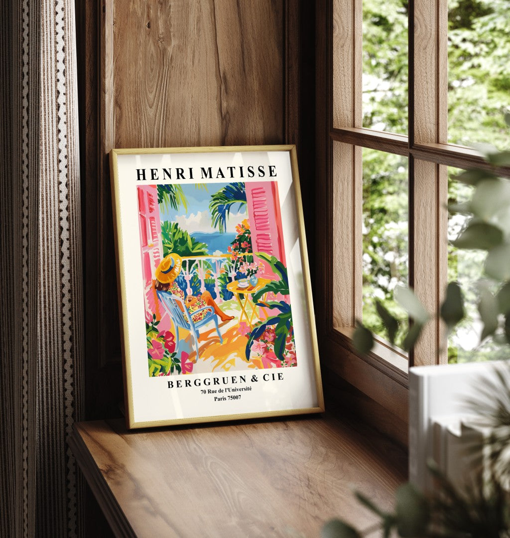 Framed art print showing woman in sun hat on terrace with sea view