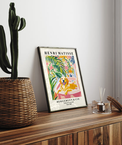 Framed artwork of a Golden Retriever in a bright, plant-filled setting.
