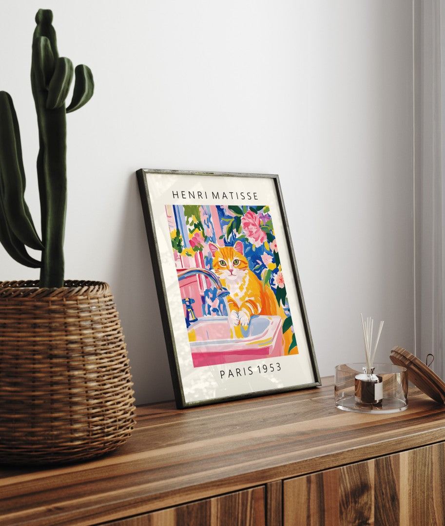 Whimsical framed bathroom wall art of orange cat washing in sink